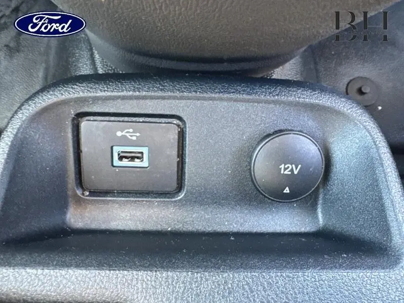 Prise USB et prise 12V noires en gros plan sur la console intérieure du Ford Transit Connect blanc glacier 2021.