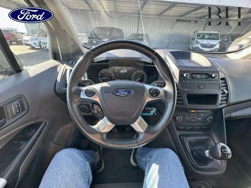 Vue intérieure du poste de conduite du Ford Transit Connect blanc glacier 2021, volant multifonction et boîte manuelle visibles.