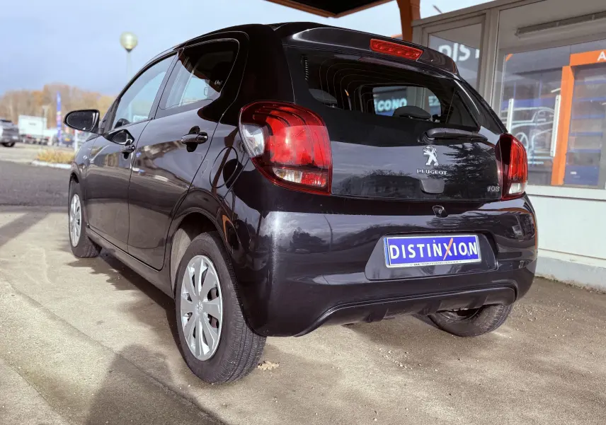 Peugeot 108 noire vue en 3/4 arrière droit, avec feux arrière rouges et plaque d'immatriculation Distinxion.
