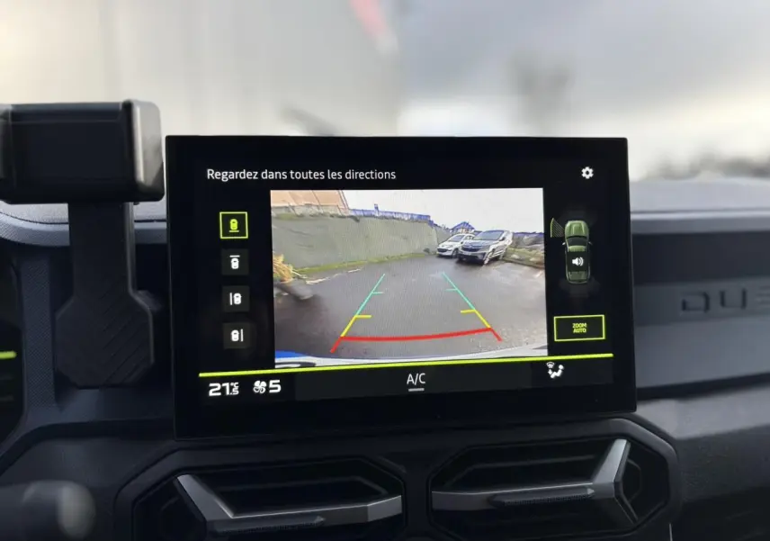 Écran central du Dacia Duster 2024 affichant la caméra de recul avec vue arrière et guidage coloré.