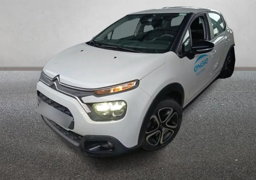 Vue 3/4 avant droit d'une Citroën C3 Société blanche avec phares allumés et logo Engie sur la porte avant.