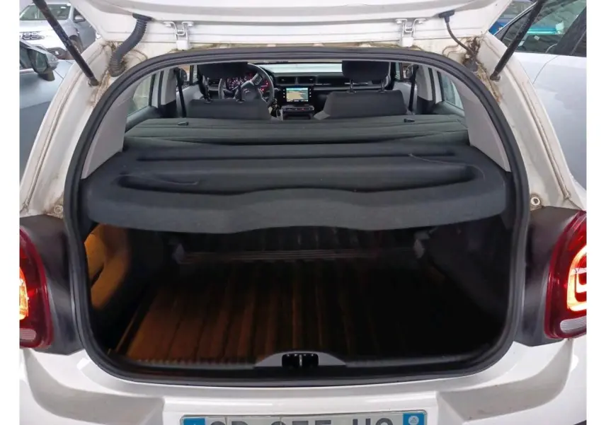 Vue arrière ouverte du coffre d'une Citroën C3 Société blanche, montrant l'intérieur et la planche cache-bagages.