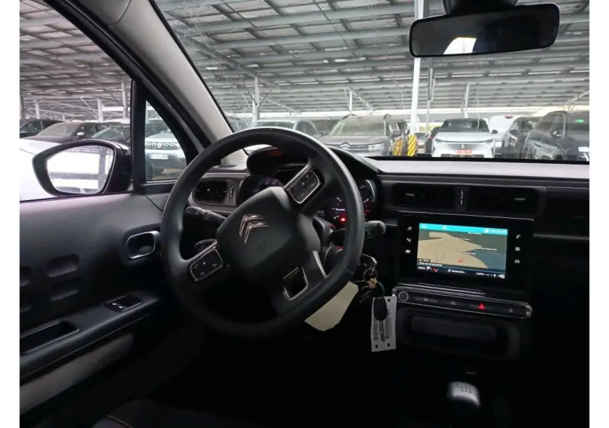 Vue intérieure côté conducteur de la Citroën C3 Société 2021 avec tableau de bord noir et écran tactile GPS allumé.