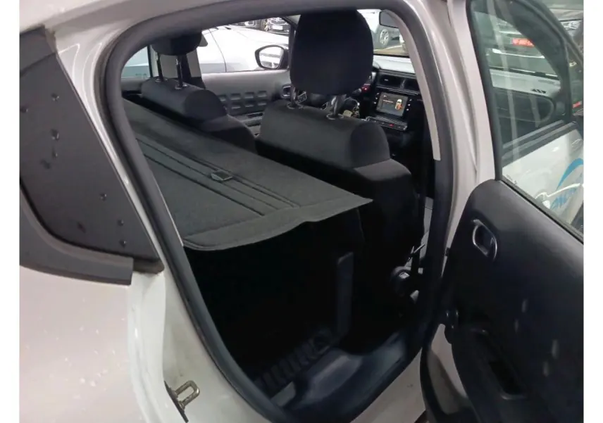 Vue intérieure côté droit de la Citroën C3 Société blanche 2021, montrant l’arrière avec tablette de coffre et sièges noirs.