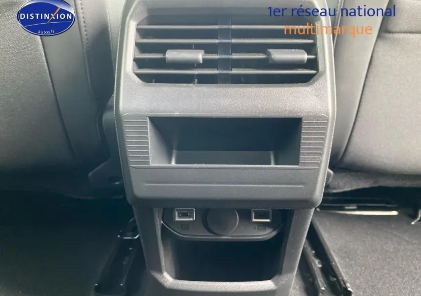 Vue rapprochée de la console arrière noire avec bouches d'aération et prises USB du Peugeot 3008 bleu 2025.