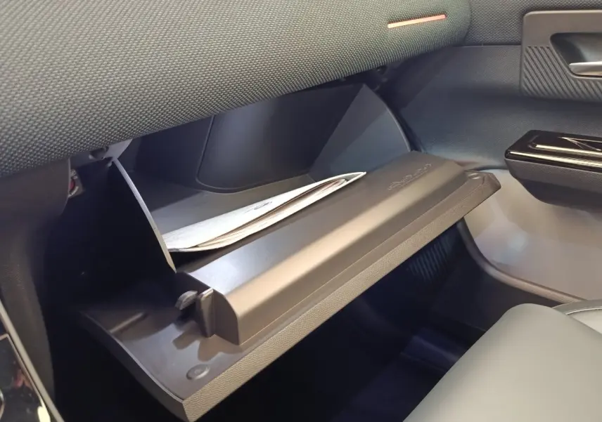 Gant de boîte à gants ouvert côté passager avec intérieur noir et document partiellement visible dans une Citroën C5 Hybride.