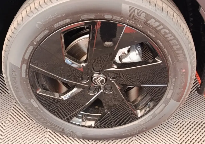 Gros plan sur la roue avant droite noire brillante d'une Citroën C5 Hybride 2026 avec pneu Michelin.