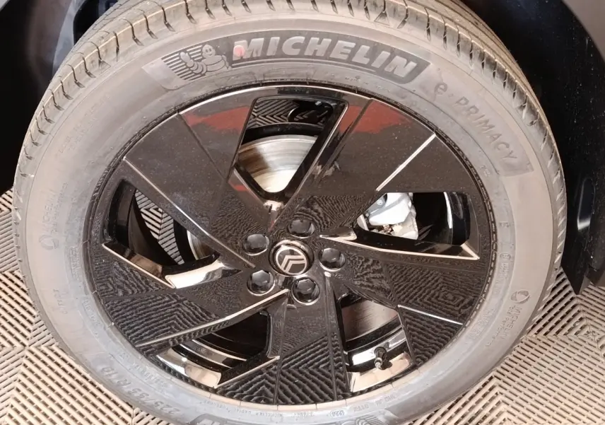 Gros plan sur la roue avant gauche de la Citroën C5 hybride 2026, jante noire brillante avec pneu Michelin.