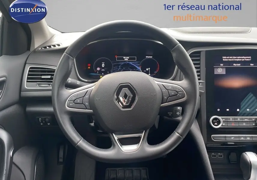 Vue intérieure centrée sur le volant et le tableau de bord numérique de la Renault Mégane Break 2024 gris Highland Metal.