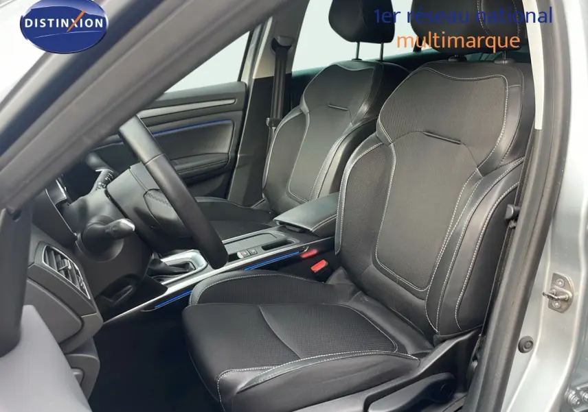 Intérieur de la Renault Mégane Break 2024 en gris Highland Metal, vue côté conducteur sur les sièges noirs en cuir et tissu.