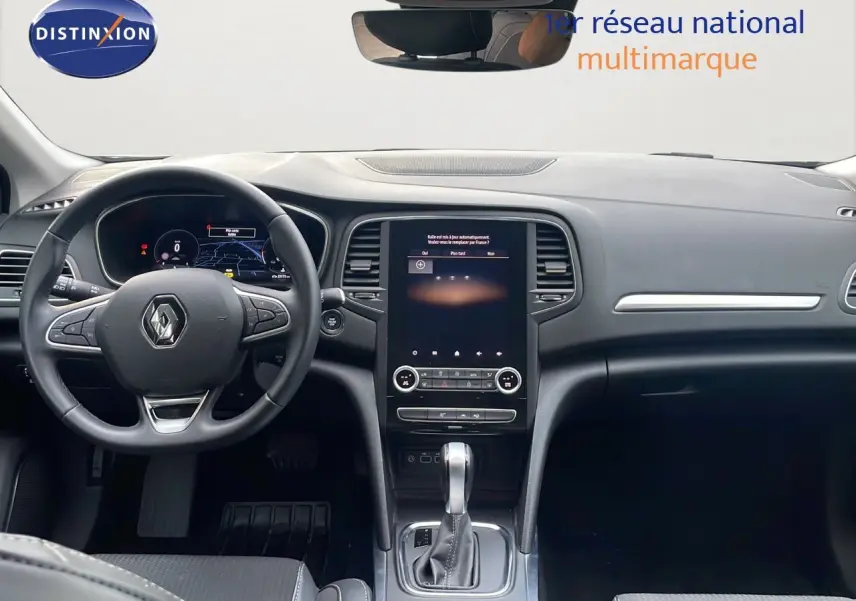 Vue intérieure du poste de conduite de la Renault Mégane Break 2024, avec volant multifonction et écran tactile central.