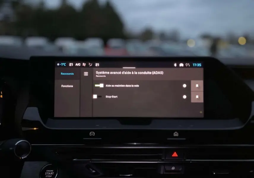 Écran tactile du système d'aide à la conduite dans l'habitacle du Citroën C5 X, ambiance sombre extérieure.