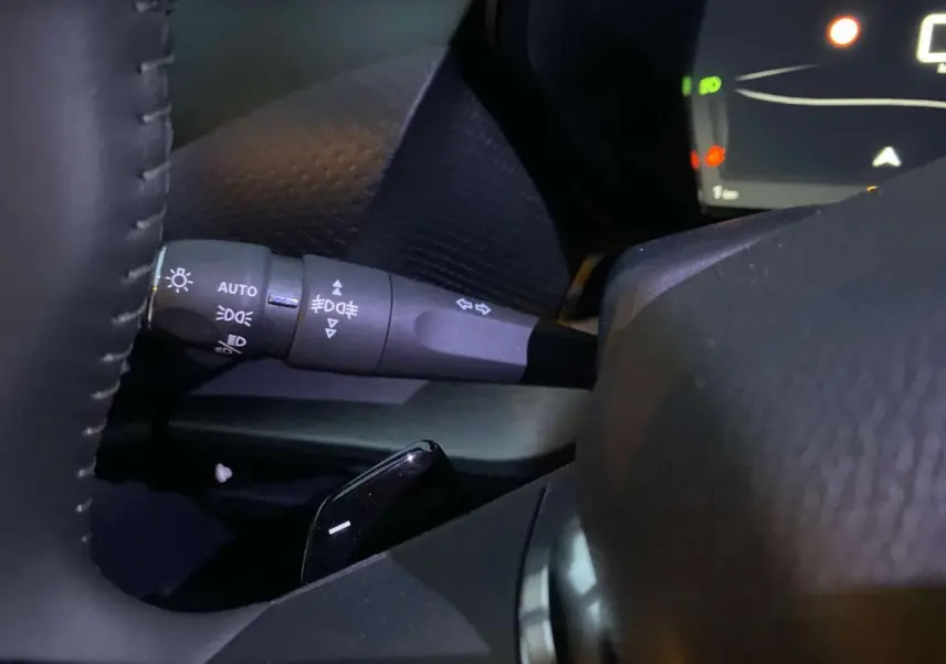 Détail du commodo d'éclairage à gauche du volant du Citroën C5 X gris Artense métal 2023.