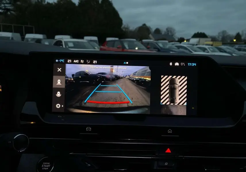 Vue de l'écran intérieur montrant la caméra de recul active d'une Citroën C5 X gris Artense métal en stationnement.