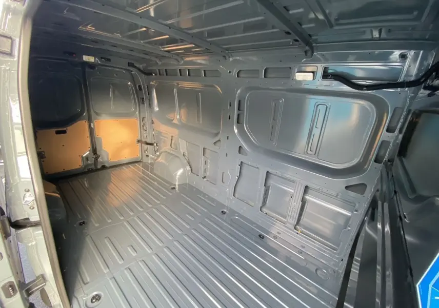 Vue intérieure arrière du Renault Master gris urbain 2025, montrant la grande zone de chargement métallique vide.