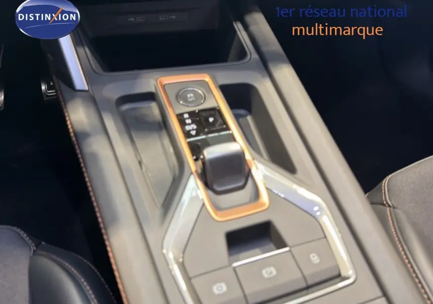 Gros plan sur la console centrale de la CUPRA LEON ST 1.5 eTSI 2025 avec insertions cuivrées et sellerie noire.