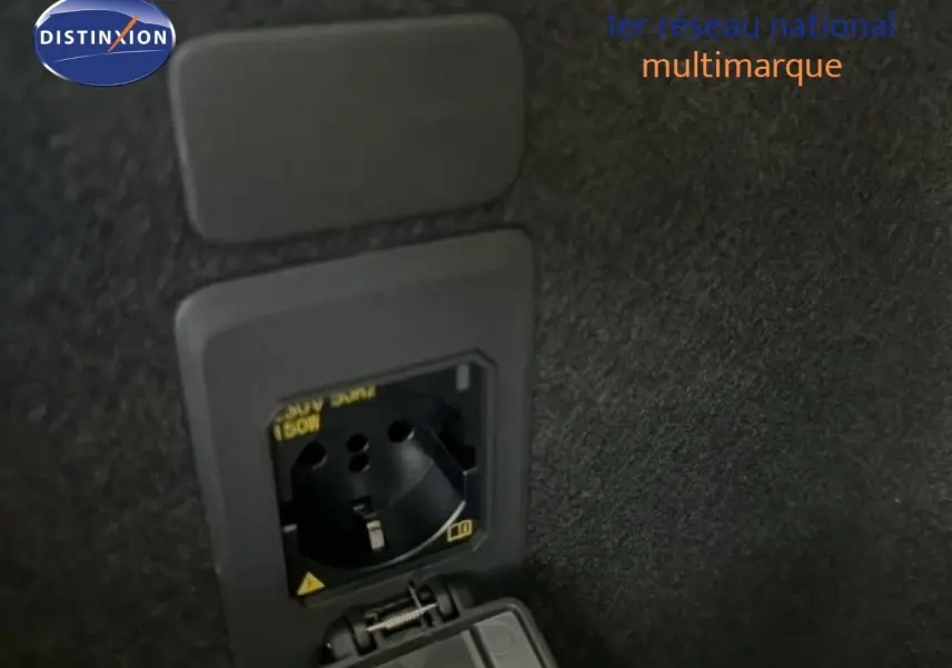 Prise électrique 230V intégrée dans le coffre du CUPRA LEON ST gris magnétique 2025, vue rapprochée intérieure.