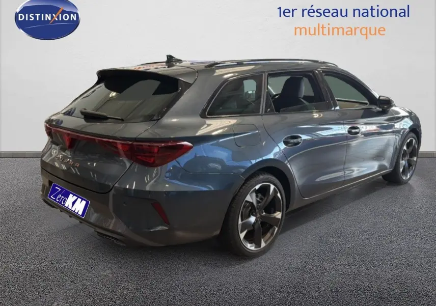 Vue 3/4 arrière droite d'une CUPRA LEON ST gris magnétique métallisé avec jantes bi-ton et feux arrière allongés.