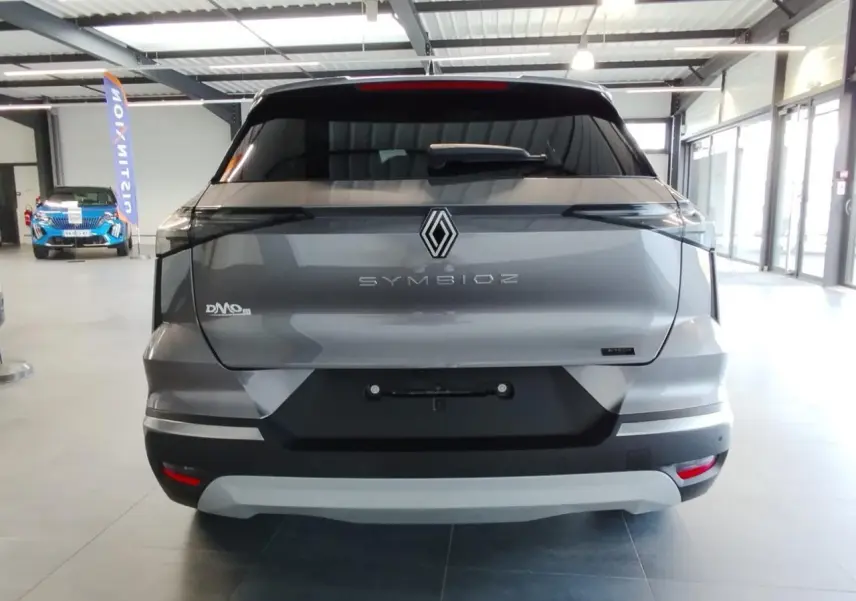 Vue arrière d'un Renault Symbioz gris Cassiopée avec logo central et feux arrière fins à LED dans un showroom.