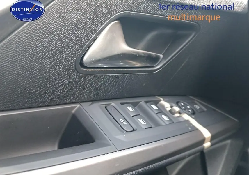 Détail de la porte côté gauche du Peugeot 3008 bleu 2025, montrant les commandes des vitres et la poignée intérieure.