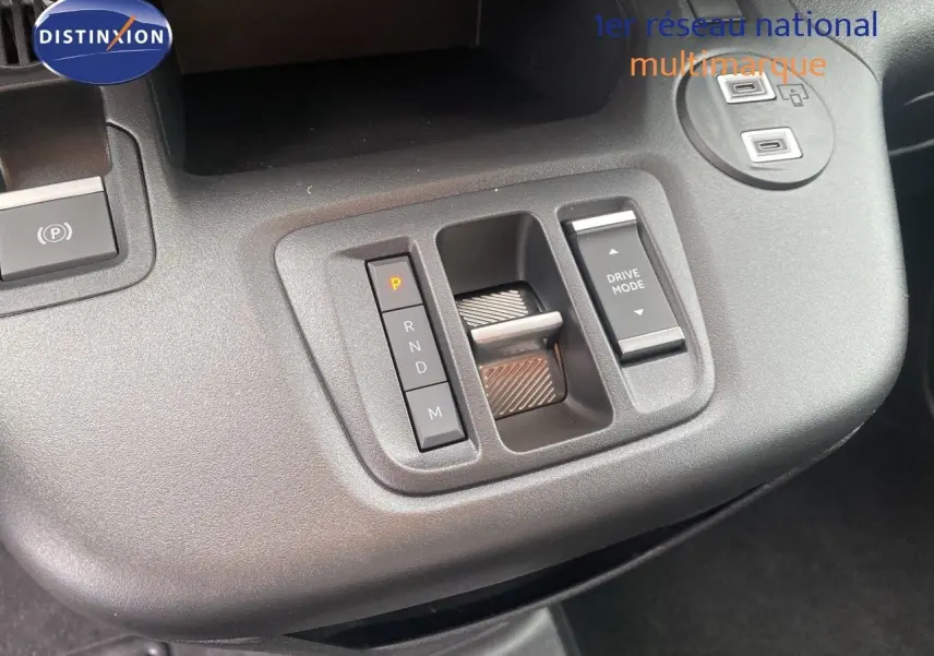 Gros plan sur la console centrale grise du Citroën Berlingo Fourgon blanc, montrant la commande de boîte auto et le bouton Drive Mode.