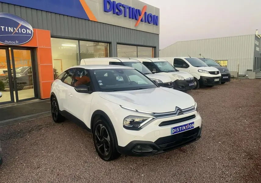 Citroën C4 blanc vue 3/4 avant droit, toit noir et jantes noires, devant concession Distinxion.