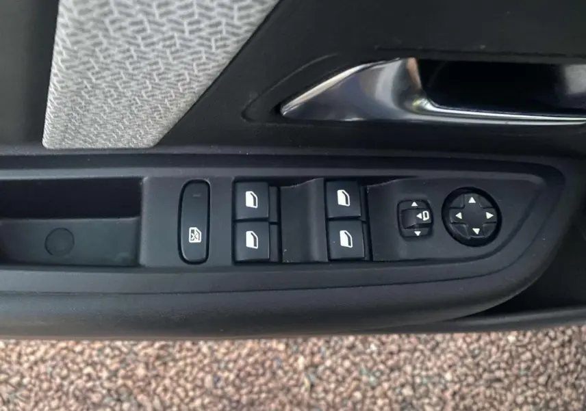 Panneau de commandes des vitres et rétroviseurs côté conducteur dans une Citroën C4 blanche de 2021.