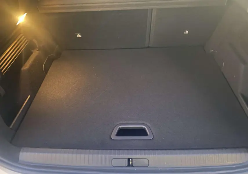 Coffre spacieux et propre de la Citroën C4 blanche 2021, vue intérieure depuis l'arrière avec plancher plat.