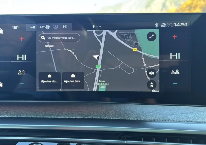 Écran tactile du système de navigation du Peugeot 3008 Hybrid 2024, affichant une carte et les commandes climatisation.