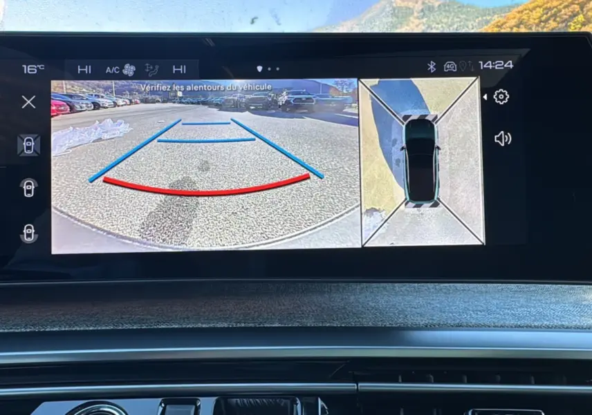 Écran central du Peugeot 3008 Hybrid 2024 montrant la caméra de recul et la vue à 360 degrés du véhicule blanc okénite.