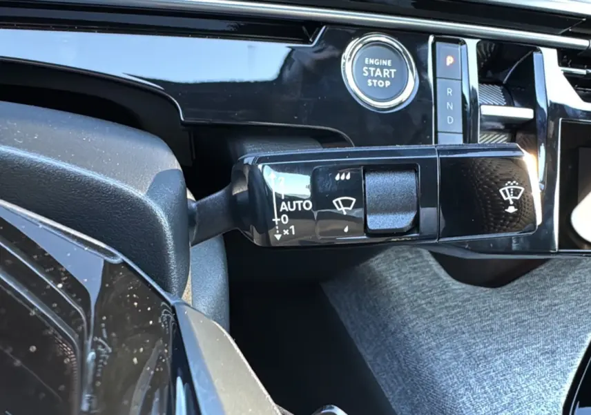 Gros plan sur la commande d'essuie-glace et le bouton start/stop du tableau de bord du Peugeot 3008 Hybrid 2024.