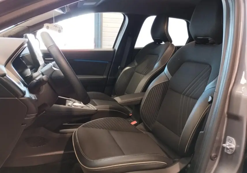 Vue intérieure côté gauche du Renault SYMBIOZ 2025 gris Cassiopée, montrant les sièges avant noirs et le volant.