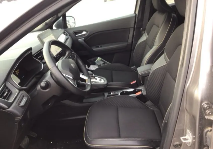 Vue intérieure côté conducteur du Renault Symbioz 2025, sièges noirs avec surpiqûres contrastées et tableau de bord moderne.