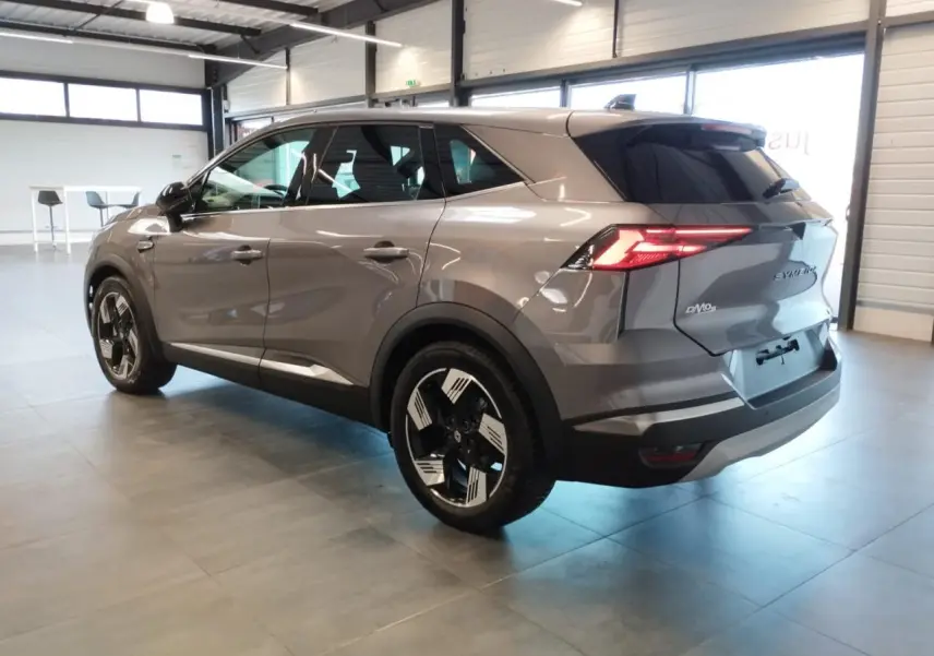 Renault SYMBIOZ gris Cassiopée en vue 3/4 arrière droit, avec jantes 18 pouces et feux arrière LED allumés.