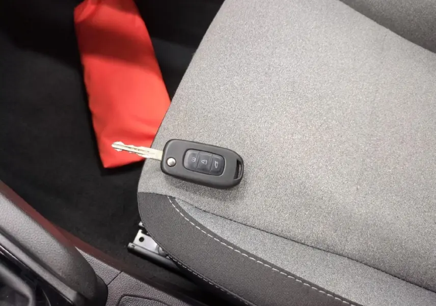 Gros plan sur la clé noire posée sur le siège tissu gris clair à motifs 3D de la Renault Clio 2024.