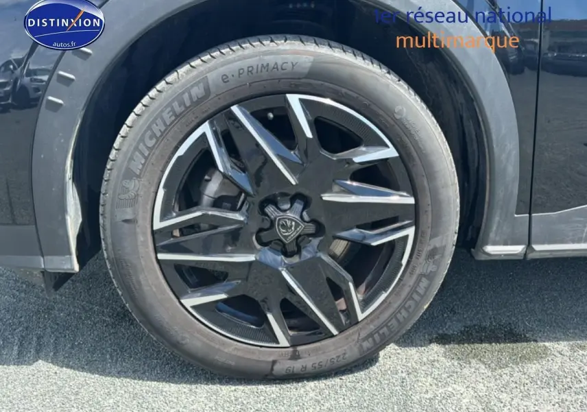 Gros plan sur la roue avant gauche noire avec jante alu au design moderne du Peugeot 5008 Hybrid 145 allure e-dcs6.