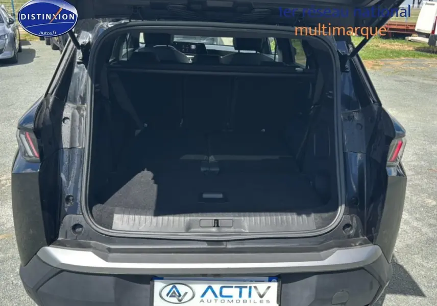 Vue arrière du coffre ouvert du Peugeot 5008 Hybrid 145 allure e-dcs6 noir, montrant l’espace de chargement avec banquette rabattue.