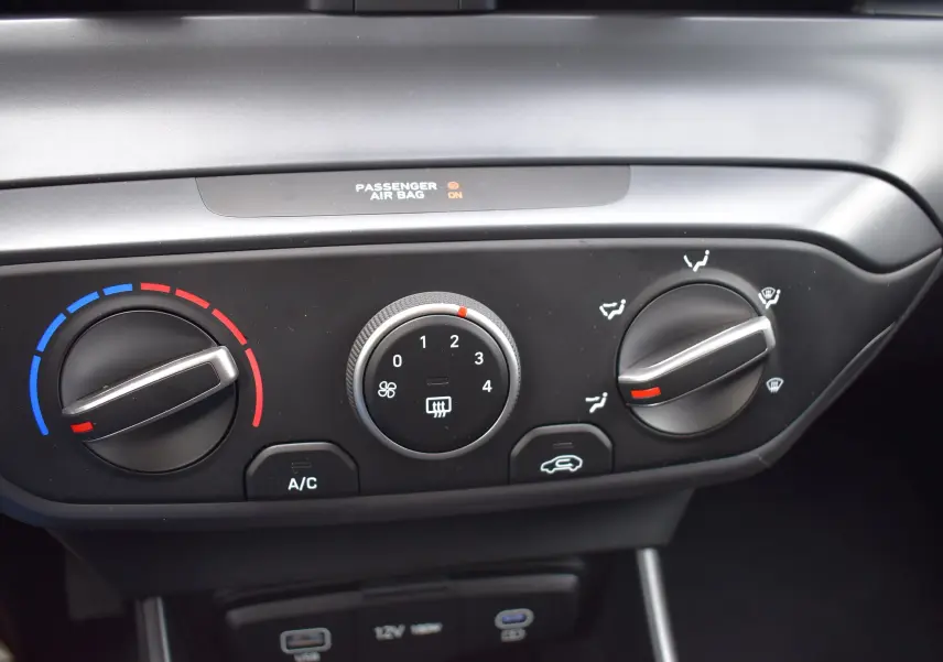 Gros plan sur les commandes de climatisation de la Hyundai i20 1.2 79 Intuitive, avec réglages manuels et indicateurs colorés.