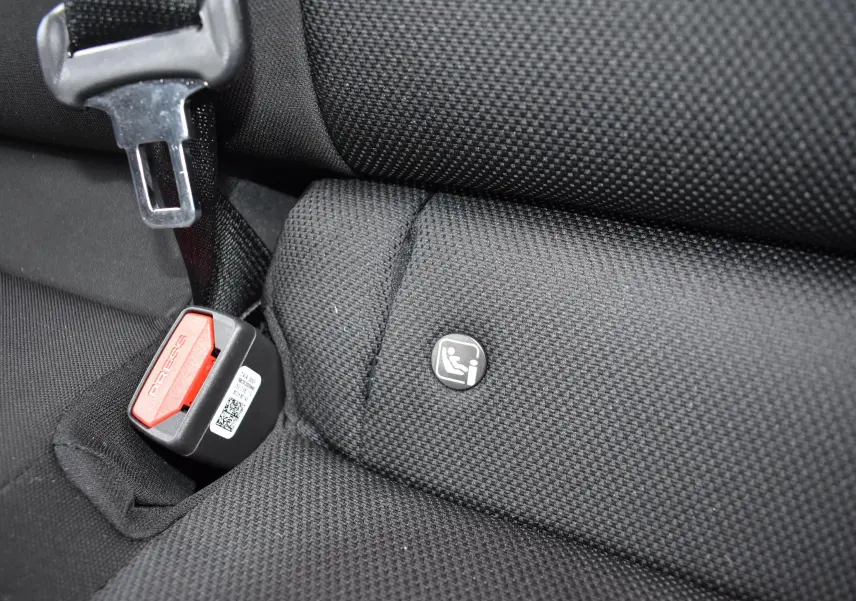 Gros plan sur la banquette arrière noire de la Hyundai i20 2025, montrant l'attache Isofix et la boucle de ceinture rouge.