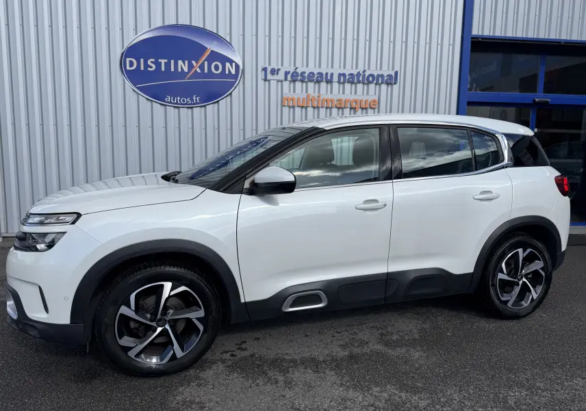 Vue de profil côté gauche d'un Citroën C5 Aircross blanc avec jantes bi-ton et protections noires sur les bas de caisse.