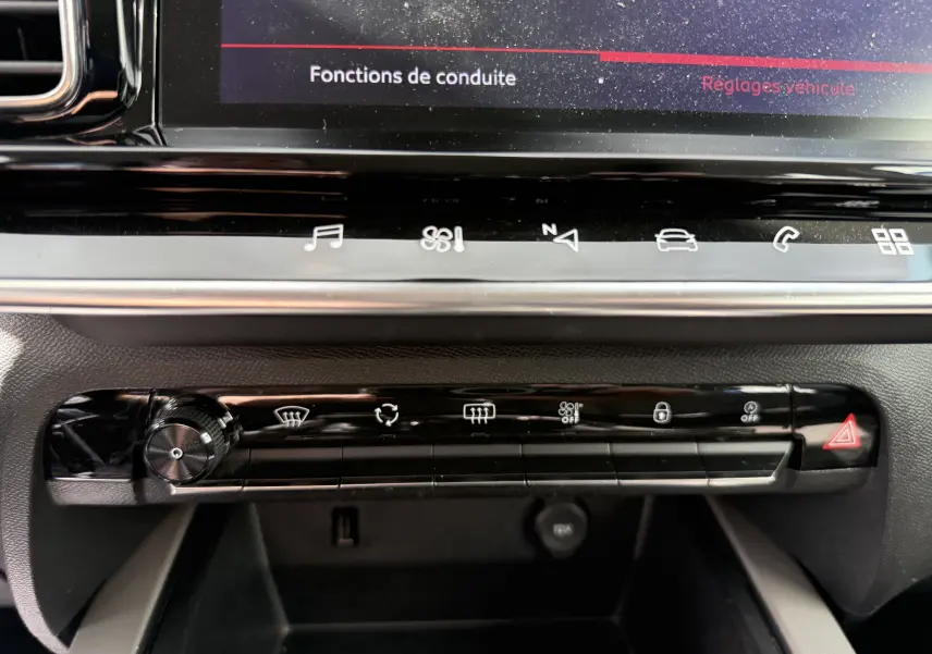 Gros plan sur la console centrale tactile du Citroën C5 Aircross 2021, boutons de commande et écran affichant fonctions de conduite.