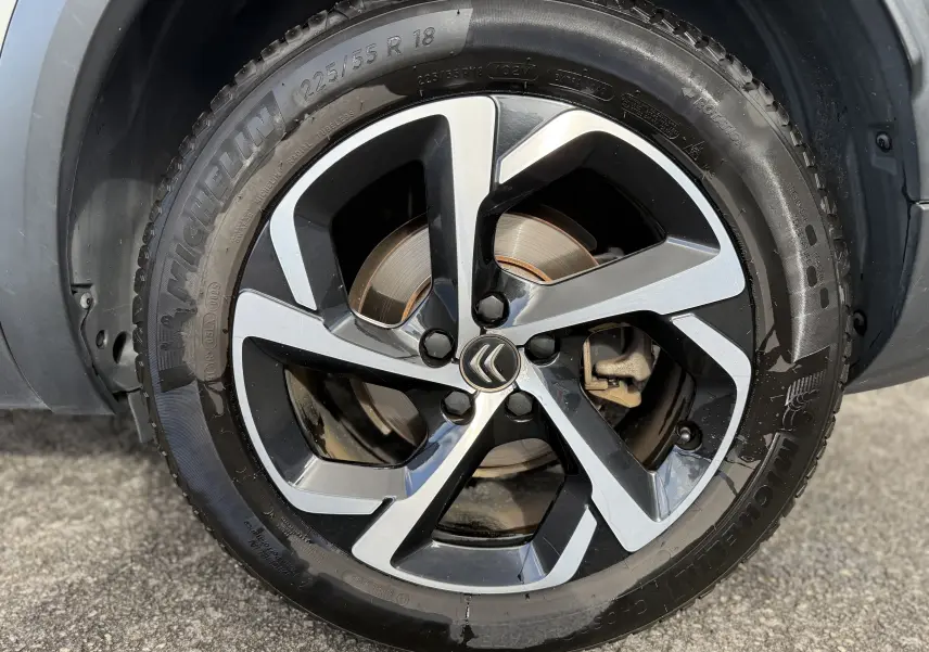 Gros plan sur la roue avant droite du Citroën C5 Aircross blanc, avec jante alliage bicolore et pneu Michelin.