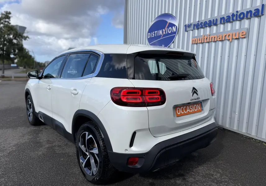 Vue 3/4 arrière droite d'un Citroën C5 Aircross blanc avec feux arrière LED et jantes bi-ton.
