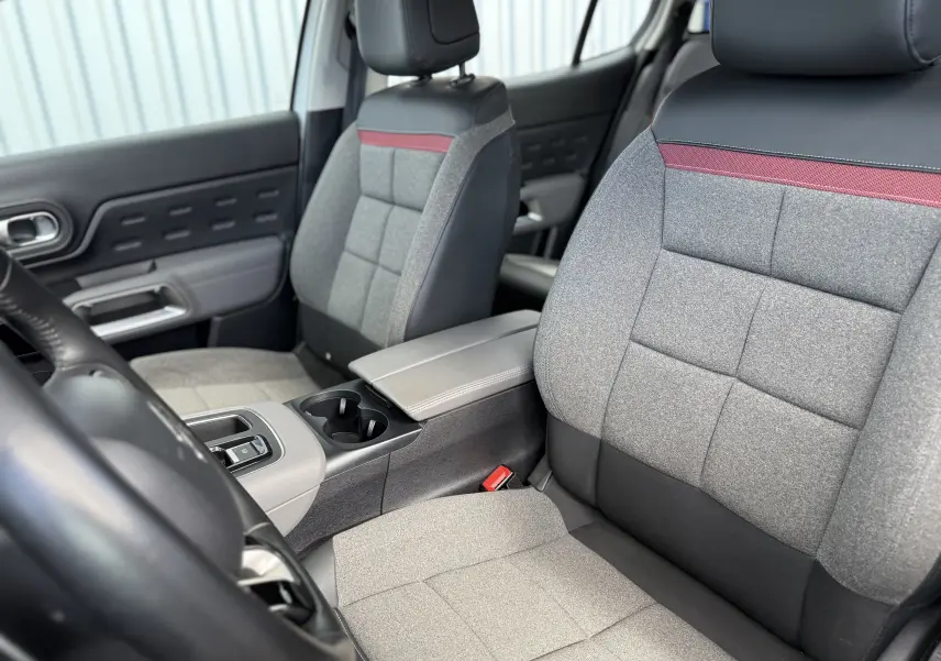 Vue intérieure rapprochée des sièges avant gris et noir avec bande rouge du Citroën C5 Aircross 2021, version Business.