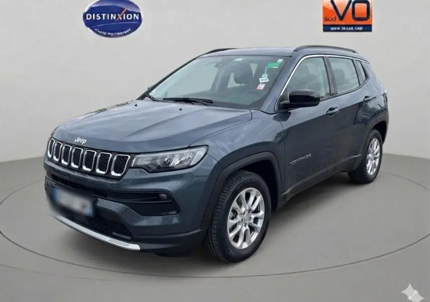 Jeep Compass bleu en vue 3/4 avant droit, avec jantes alliage 18 pouces et calandre distinctive à sept ouvertures.