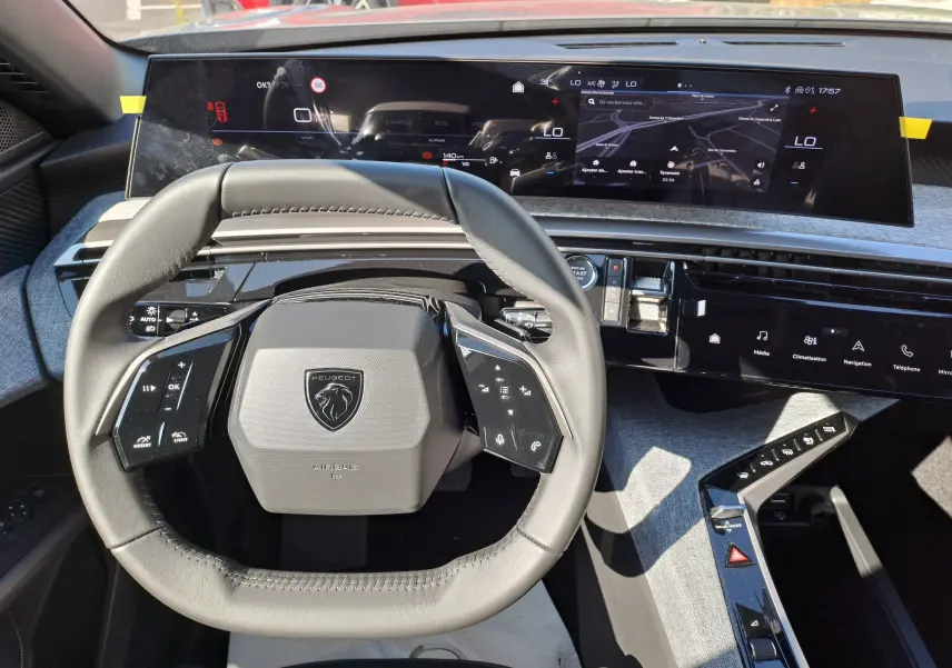 Vue plongeante sur le volant et le tableau de bord numérique du Peugeot 3008 gris Artense, intérieur moderne et épuré.