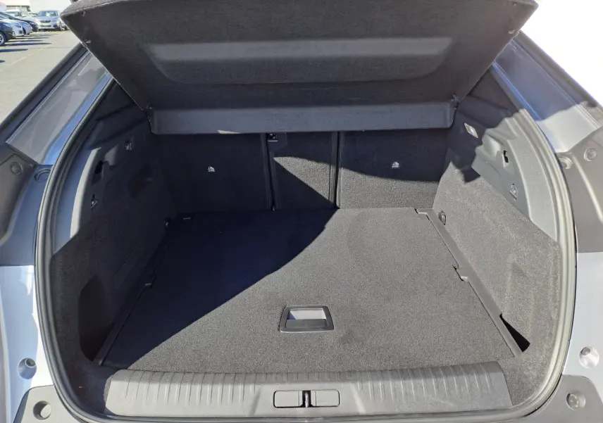 Coffre ouvert du Peugeot 3008 gris Artense, vue arrière montrant un espace de chargement propre et spacieux.