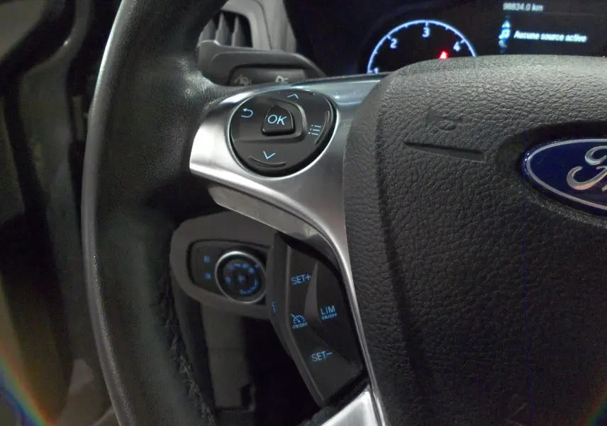 Gros plan sur le volant du Ford Grand Tourneo Connect 2020, avec commandes multifonctions rétroéclairées en bleu.