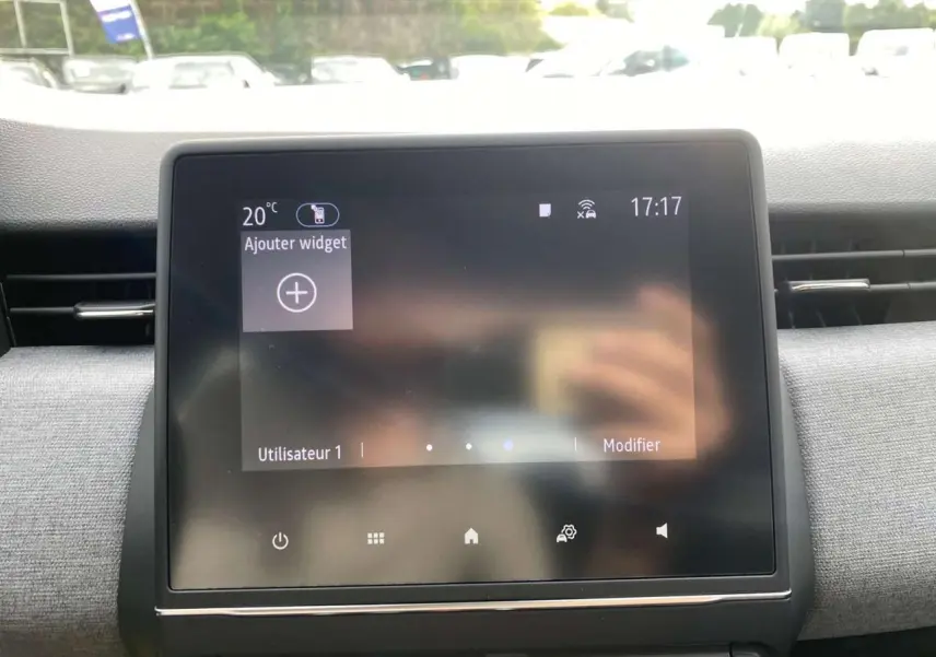 Écran tactile central de la Renault Clio 2025 avec tableau de bord gris et aérateurs latéraux visibles.