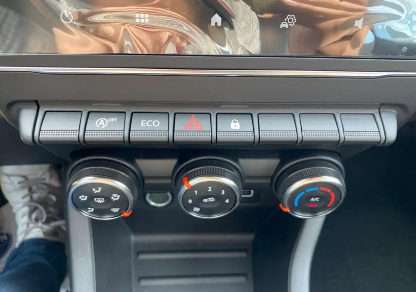 Gros plan sur la console centrale de la Renault Clio 2025 avec commandes de climatisation et boutons fonctionnels.